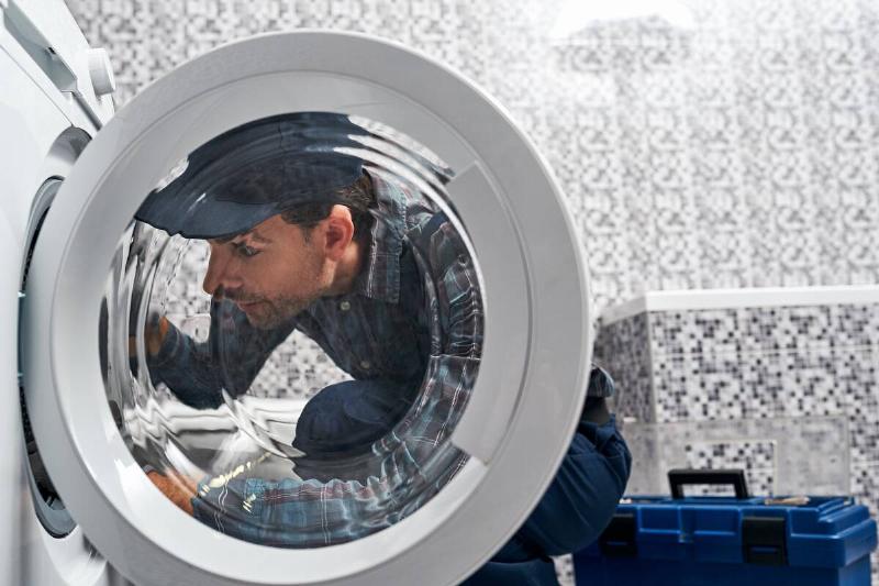 it-s-easy-working-man-plumber-in-bathroom-checkin-2025-03-25-13-48-21-utc Man installing a dryer.