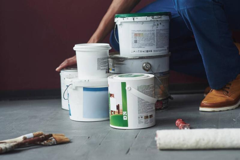 items-on-the-floor-young-african-american-worker-2025-03-18-20-22-40-utc Different cans of paint on the floor.