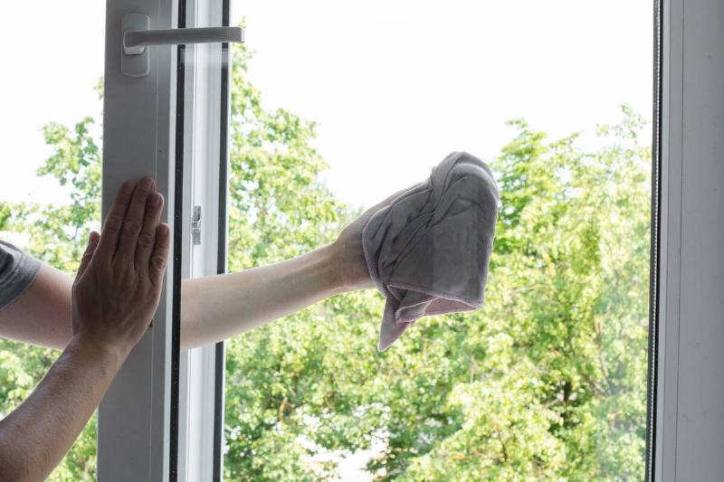 male-worker-keeping-rag-in-hand-and-wiping-window-2025-02-12-03-47-32-utc Man using towel to clean windows.