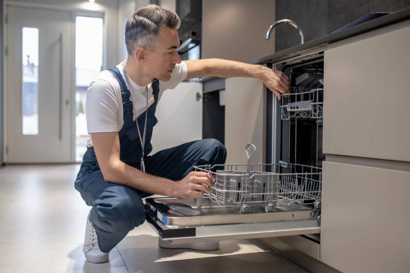 man-carefully-examining-an-open-dishwasher-2024-10-16-23-29-43-utc Man cleaning the inside of dishwasher.