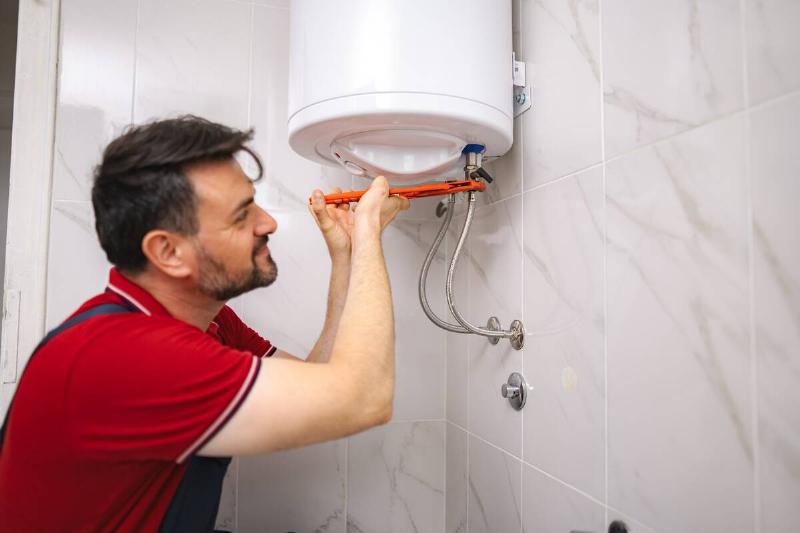 plumber-fixing-a-water-heater-in-a-bathroom-2025-08-27-10-28-20-utc Plumber installing a water heater in the bathroom.