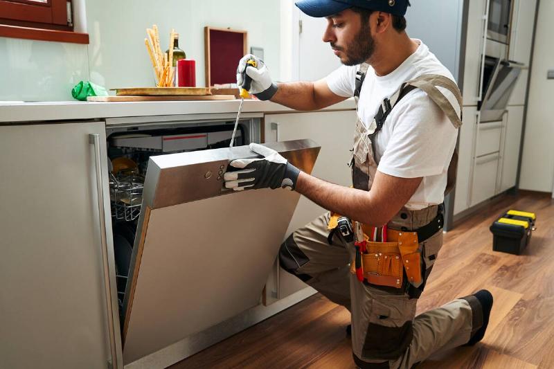 professional-service-worker-repairing-dishwasher-a-2024-10-18-08-12-17-utc Professional installing a dishwasher.