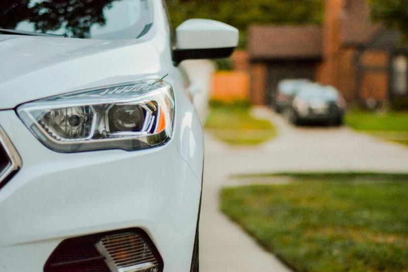 Close-up of a white SUV parked in a residential driveway