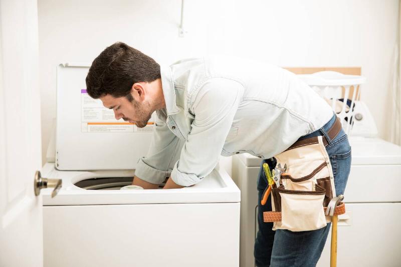 technician-repairing-a-washer-2025-05-19-09-39-06-utc Technician installing a washing machine