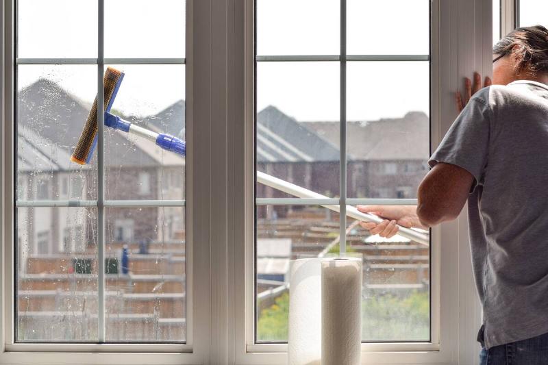woman-washing-dirty-windows-with-telescopic-window-2025-03-12-21-53-16-utc Woman washing dirty windows with extendable telescopic window cleaning pole.