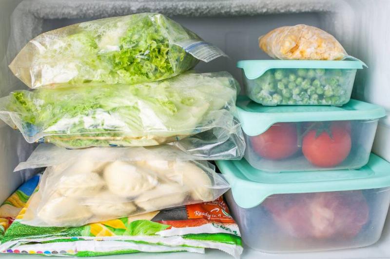 Bags and containers filled with food in a freezer