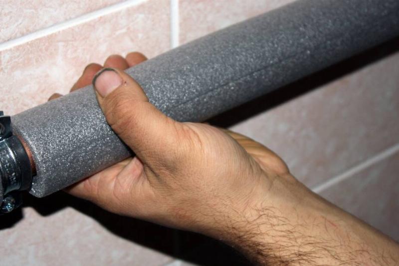 Hand holding pipe with noodle.