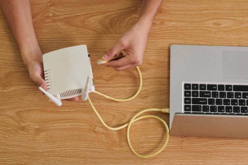 Old router being plugged into laptop.