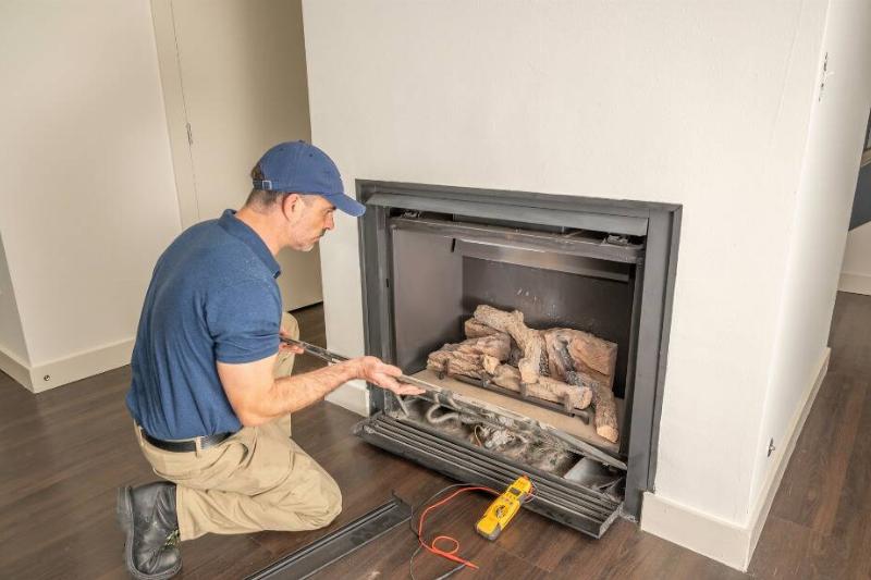 Technician doing maintenance on a fireplace.