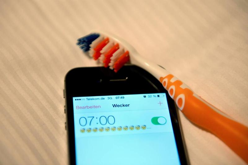 A toothbrush beside a phone. 