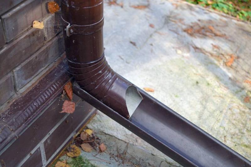 A drain downspout on the outside of a house. 