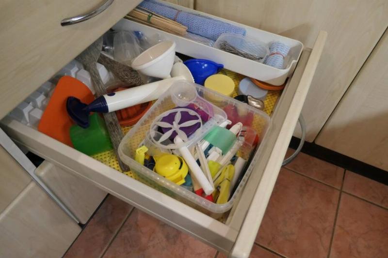 A messy drawer with one container for organization. 