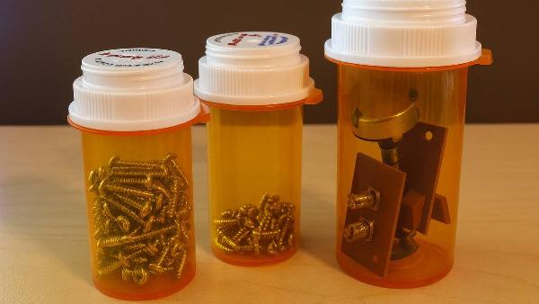 A pill bottle being used to store metal scraps.
