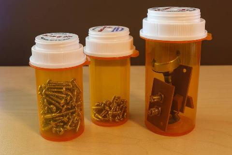 A pill bottle being used to store metal scraps.