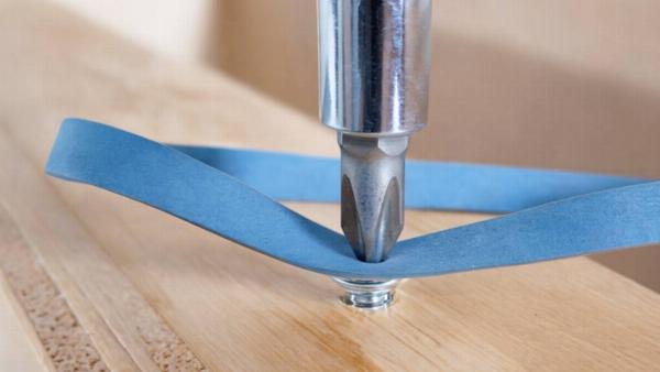 A rubber band in between a screw driver and a screw. 