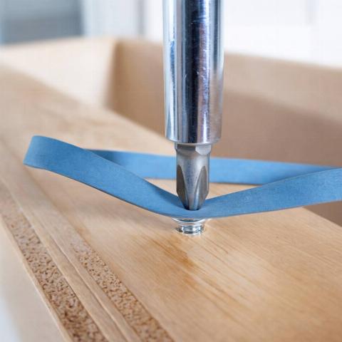 A rubber band in between a screw driver and a screw. 