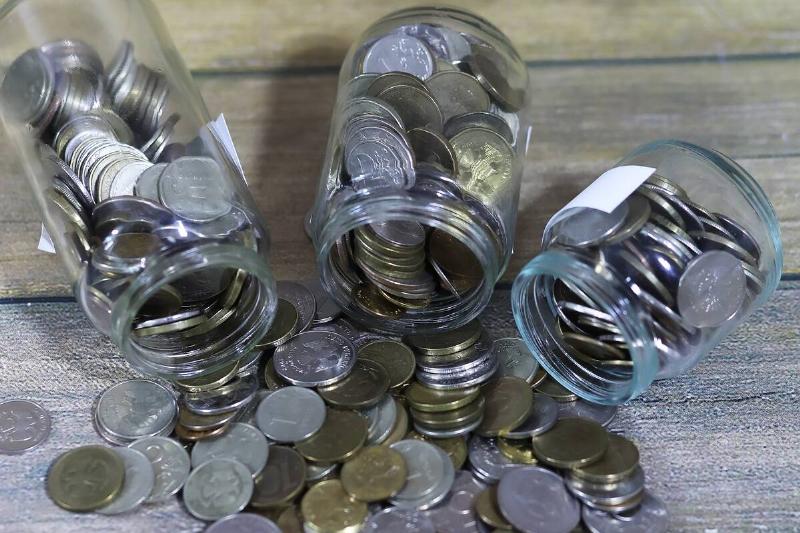 накопленные-монеты-сложены-в-стеклянных-банках-на-флоу-2025-10-17-02-27-33-utc Монеты высыпаются из трех стеклянных банок.