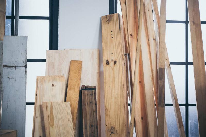 Wood leaned on a wall in a workshop.