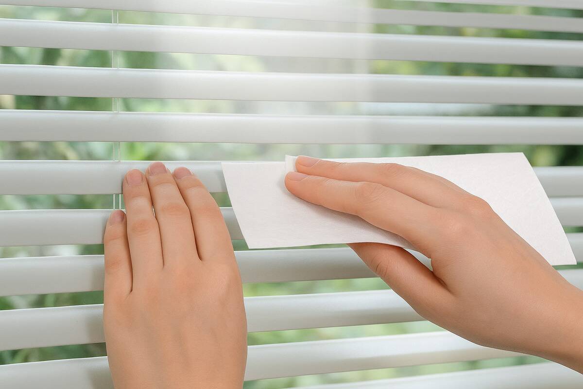 Blinds being cleaned with a dryer sheet. 