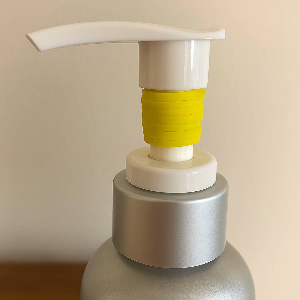 A rubber band wrapped around a bottle with a pump dispenser. 