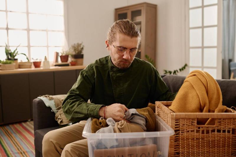 Man packing up clothes to donate.