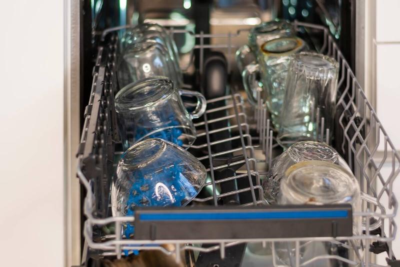 An open dishwasher with glasses.