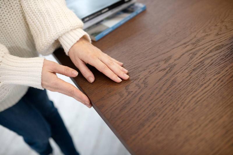 Woman touching hardwood table. 