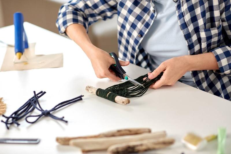 Persona making macrame with upcycled materials.