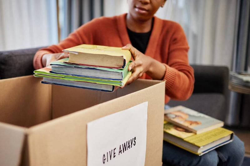 Woman putting books in donations box.