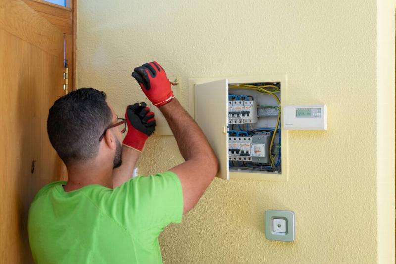Man working on fuse box.