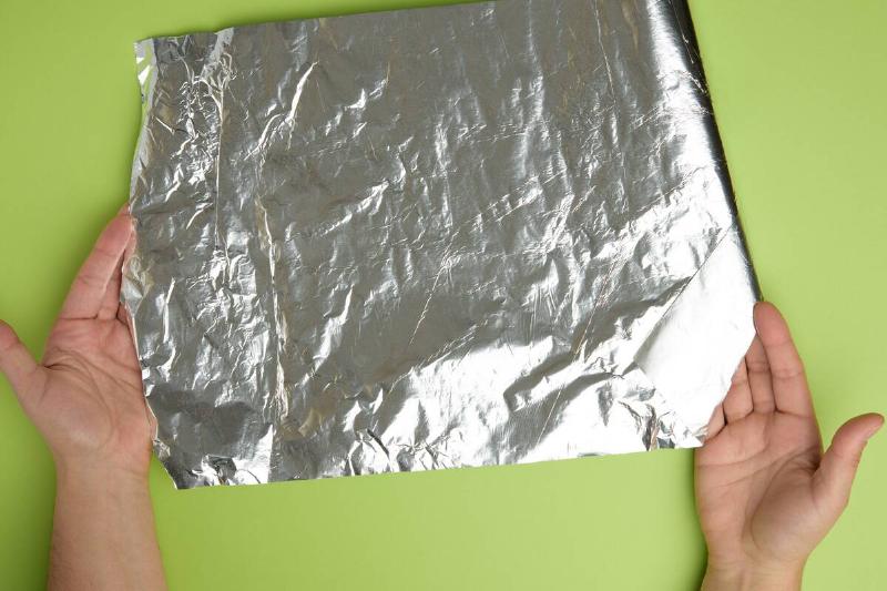Hands holding aluminum foil.