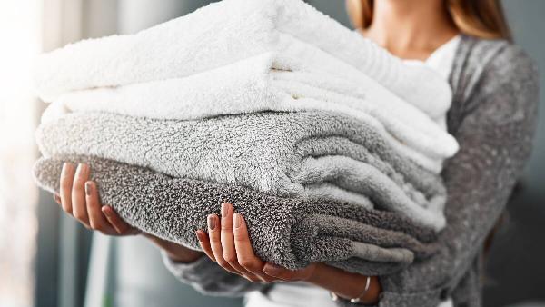Woman holding fluffy towels.
