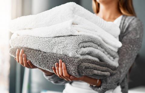Woman holding fluffy towels.