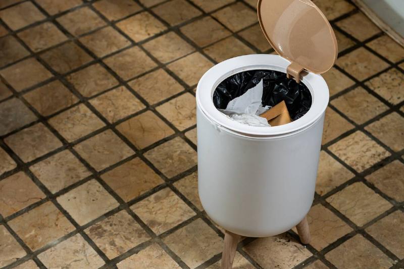 Open garbage can on kitchen floor.