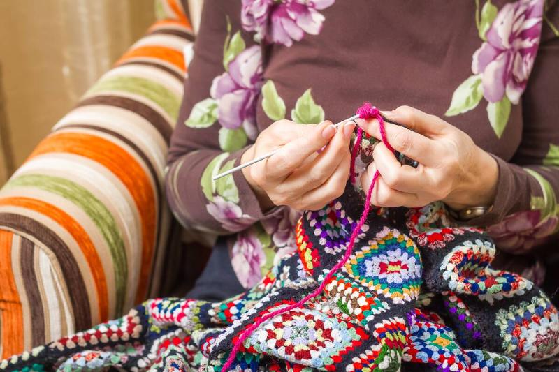 Person crocheting banket. 