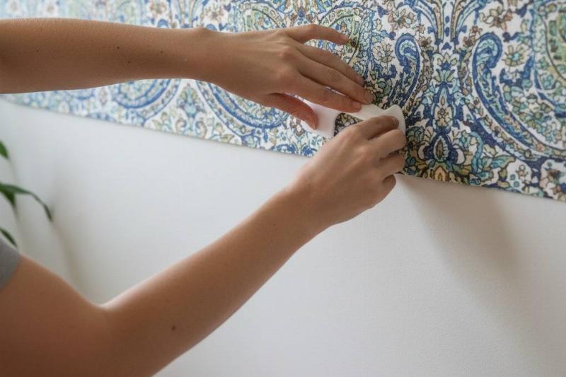 Hands hiding the seam by layering sheets.