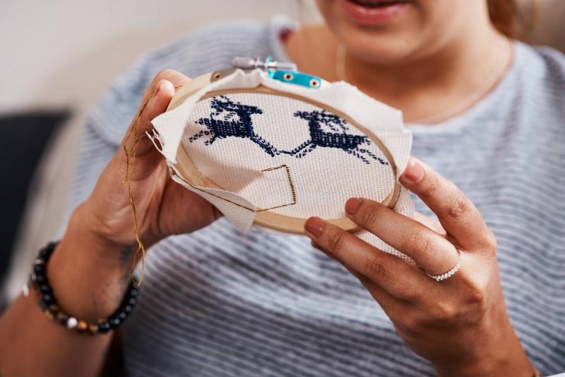 Persona embroidering a pattern. 