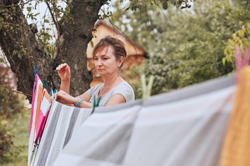 Woman hanging laundry out to dry on line. 