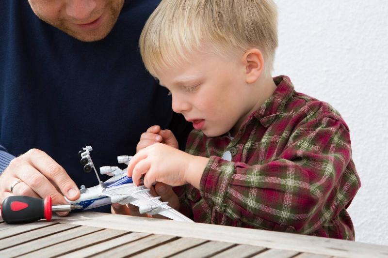Man teaching his son about batteries. 