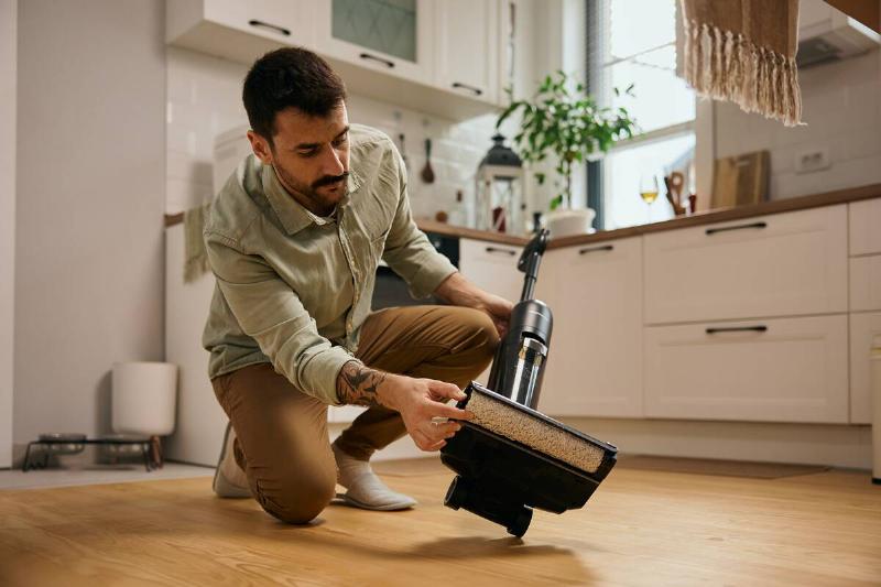 Man putting vacuum cleaner back together. 
