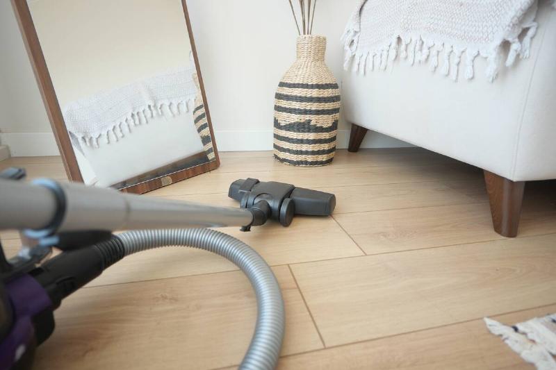 Vacuum cleaning around edges or room.