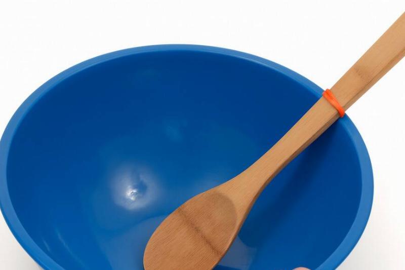 нескользящая резинка для ложки Деревянная ложка в миске с резинкой на одном конце.