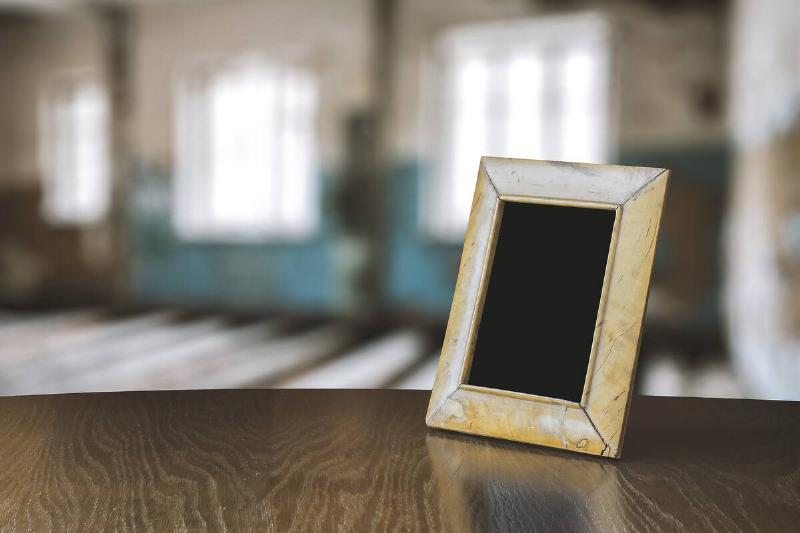 Old photo frame on wooden table. 