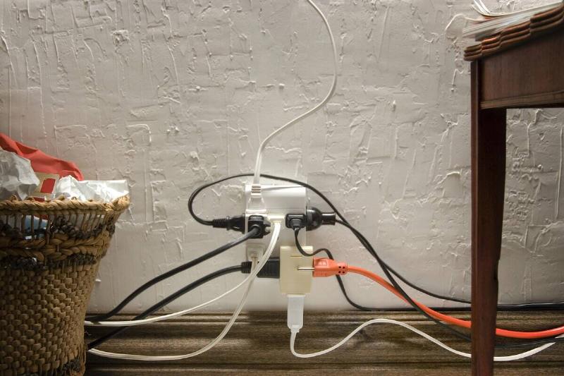 Overloaded electrical socket in home office.