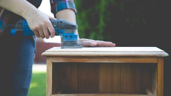 Remove finish from wood furniture with electric sander. 