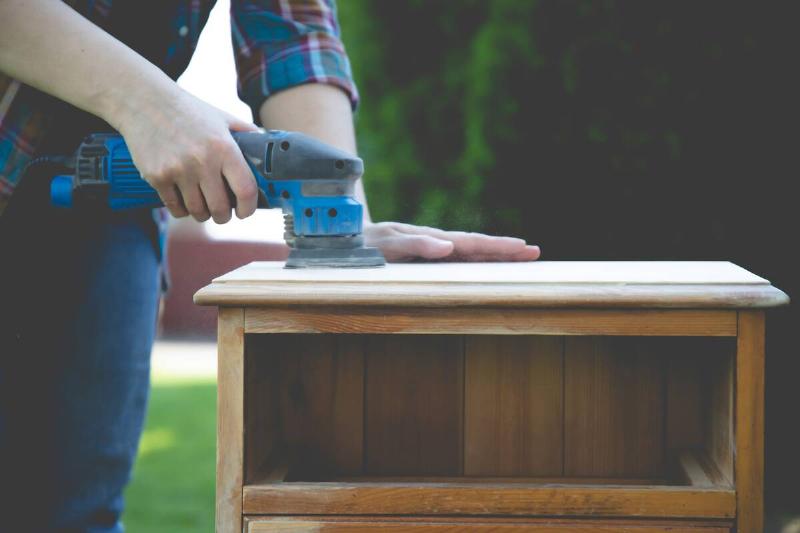 Remove finish from wood furniture with electric sander. 
