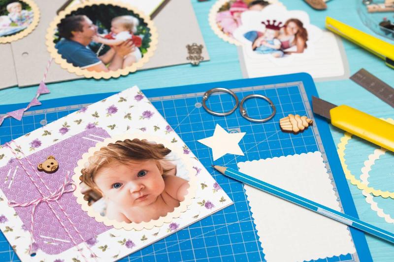 Person making a scrapbook of baby photos.