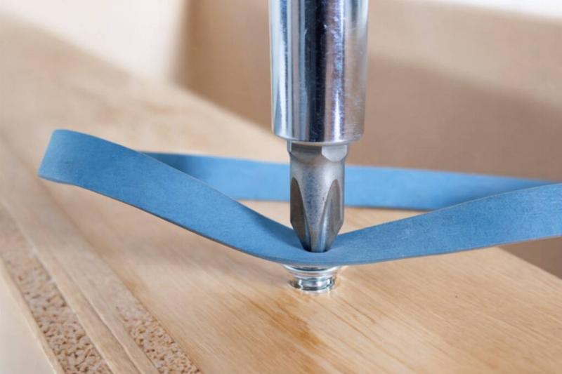 A screwdriver drilling through a rubber band. 