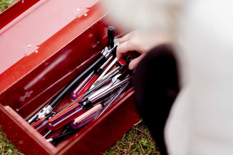 Person reaching into a toolbox. 