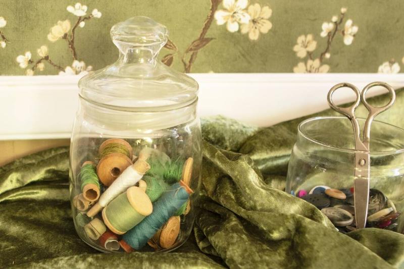 Glass jars used to hold sewing supplies. 